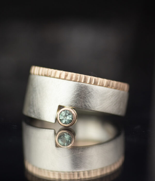 platinum and 14K rose gold mixed metals geo cut out alternative engagement ring with teal sapphire and textured wedding band