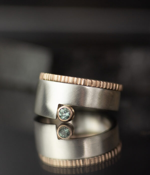 platinum and 14K rose gold mixed metals geo cut out alternative engagement ring with teal sapphire and 14K rose gold textured wedding band