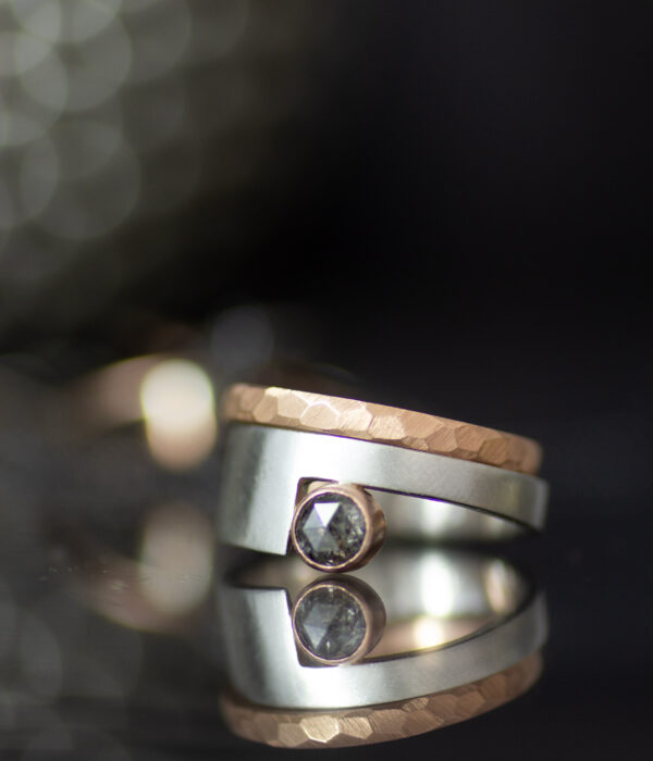 platinum and 14K rose gold non binary modern engagement ring with rose cut salt and pepper sapphire and faceted wedding band