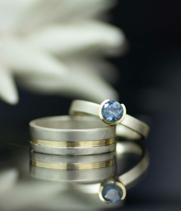 Montana sapphire half bezel solitaire mixed metals engagement ring and gender neutral wedding band