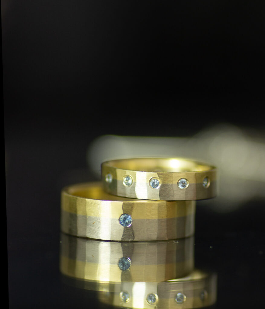chiseled fusion band in 14K yellow and 14K palladium white gold wedding band set with blue montana sapphires