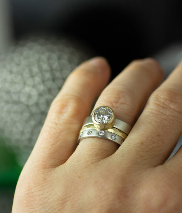 on hand 14K mixed metals gold bezel set moissanite mixed metals engagement ring wedding band set