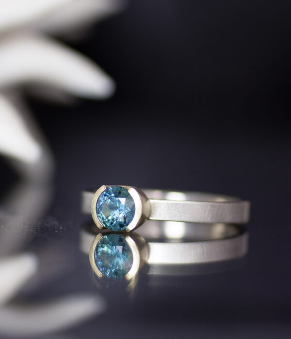 side view Montana teal sapphire modern half bezel alternative engagement ring in 14K white and yellow gold